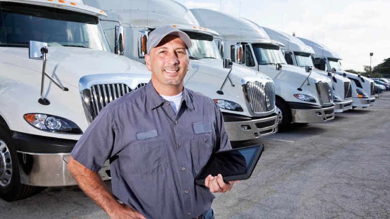 Driver Standing in Front of a Line of Trucks